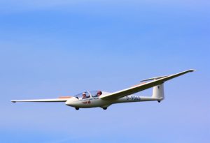 A DO-254 compliant glider aircraft in flight against a clear blue sky. | Afuzion